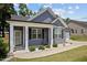 Inviting front porch with classic white columns, gray siding, and manicured landscaping details at 36 Mae Ct, Roxboro, NC 27573