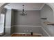 Simple dining room with chandelier, hardwood floors, and floating shelves at 4202 Cherry Blossom Cir, Durham, NC 27713