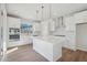 Bright kitchen features white cabinets, quartz counters, stainless appliances, and a large center island at 4717 Cypress Tree Ln, Raleigh, NC 27612