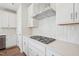 Bright white kitchen offers stainless hood over cooktop and quartz counters at 4717 Cypress Tree Ln, Raleigh, NC 27612
