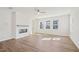 Spacious living room featuring fireplace, light hardwood floors, and a ceiling fan at 4717 Cypress Tree Ln, Raleigh, NC 27612