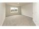 Bright, carpeted bedroom with a window providing natural light and a view of the neighborhood at 514 Glenkirk Pl, Garner, NC 27529
