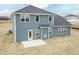 View of the rear of this two story home with blue siding, white trim and a small patio at 514 Glenkirk Pl, Garner, NC 27529