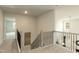 Carpeted hallway with decorative railings and views to the living room below at 514 Glenkirk Pl, Garner, NC 27529