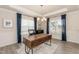 Well-lit home office with large windows, wood-look floors, and a stylish chandelier and comfortable black office chair at 514 Glenkirk Pl, Garner, NC 27529