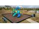 Community playground with slides, a bench, pea gravel, and surrounding green space at 514 Glenkirk Pl, Garner, NC 27529