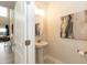Powder room with modern sink and round mirror with an adjoining living space and lots of natural light at 514 Glenkirk Pl, Garner, NC 27529