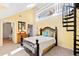 Bedroom with a spiral staircase, and a black metal bed frame, leading to a loft area at 5765 G Snow Camp Rd, Graham, NC 27253
