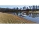 Picturesque pond featuring a dock and tranquil waterfront at 5765 G Snow Camp Rd, Graham, NC 27253