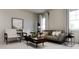 Living room with brown couch, wood coffee table, and large windows at 613 Emerald Bay Cir, Raleigh, NC 27610