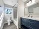 Updated bathroom with navy vanity, white tub, and grey tile at 6307 Tryon Rd, Cary, NC 27518