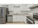 Well-equipped kitchen features stainless steel appliances, updated countertops, and sleek white cabinets at 642 Pine Ridge Pl, Raleigh, NC 27609