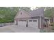 Two-car garage with white doors and a basketball court at 7115 Laurel Point Dr, Gibsonville, NC 27249