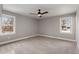 Well-lit bedroom featuring carpet, ceiling fan and two windows at 753 Quarterhorse Rd, Princeton, NC 27569