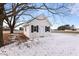 White shed with black shutters nestled under a tree in a snowy yard at 753 Quarterhorse Rd, Princeton, NC 27569