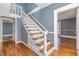 White staircase with wooden railing in a gray-walled hallway at 801 N Mebane St, Burlington, NC 27217