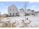 Two-story home with gray siding, attached garage, and snowy front yard at 803 Golden Plum Ln, Zebulon, NC 27597