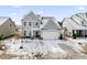 Two-story home, gray siding, attached garage, snowy yard at 803 Golden Plum Ln, Zebulon, NC 27597