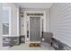 Inviting front entry with gray door, stone accents, and wicker chair at 803 Golden Plum Ln, Zebulon, NC 27597
