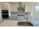 Bright kitchen featuring white cabinets, drawers, and a stainless steel range hood and oven at 85 N Stagecoach Dr, Wendell, NC 27591