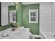 Stylish bathroom with green walls, white subway tile, and bathtub at 919 Fiske St, Durham, NC 27703