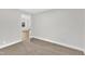 Simple bedroom with carpet, open door to another room, and neutral walls at 919 Fiske St, Durham, NC 27703