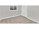 Well-lit bedroom featuring carpet, window, and double closet at 919 Fiske St, Durham, NC 27703