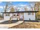 Charming ranch home with white exterior, wood accents, and landscaped yard at 919 Fiske St, Durham, NC 27703