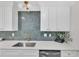 Stylish kitchen with white cabinets, hexagon tile backsplash, and gold fixtures at 919 Fiske St, Durham, NC 27703
