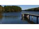 Scenic lake view with a dock extending into the water, surrounded by lush green trees on a sunny day at 101 Ailey Brook Way # 100, Wake Forest, NC 27587