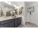 Bathroom featuring double sinks, modern vanity, sleek fixtures, a decorative mirror and stylish decor at 105 Ailey Brook Way # 100, Wake Forest, NC 27587