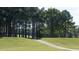 Scenic golf course featuring a green fairway lined with tall trees and a paved path winding through the landscape at 105 Ailey Brook Way # 100, Wake Forest, NC 27587