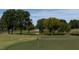 An idyllic golf course with a lush green fairway, a pond reflecting the surrounding trees, and a distant white building at 105 Ailey Brook Way # 100, Wake Forest, NC 27587