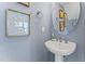 Chic powder room with a pedestal sink, decorative mirror, and serene blue walls at 105 Ailey Brook Way # 100, Wake Forest, NC 27587