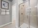 Modern shower with glass door, neutral tile, and sleek fixtures inside a bright and airy bathroom at 105 Ailey Brook Way # 100, Wake Forest, NC 27587