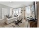 Bright living room featuring a white sofa, decorative pillows, and light filtering curtains at 109 Ailey Brook Way # 100, Wake Forest, NC 27587
