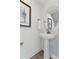 Stylish powder room features a pedestal sink, round mirror, and framed artwork at 109 Ailey Brook Way # 100, Wake Forest, NC 27587
