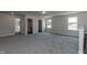 Large bonus room with carpet flooring, natural light from windows, and access to multiple rooms at 128 High Hampton Way, Fuquay Varina, NC 27526