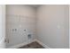 Laundry room featuring gray tile flooring, wire shelving, and washer and dryer hookups at 128 High Hampton Way, Fuquay Varina, NC 27526