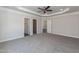 Main bedroom features a tray ceiling, ceiling fan, and neutral carpeting at 128 High Hampton Way, Fuquay Varina, NC 27526