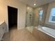 Bathroom featuring a shower with glass door and tile surround next to soaking tub at 15 Long Needle Ct # 38, Youngsville, NC 27596
