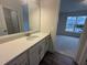 Bright bathroom with a large mirror, white cabinetry, and solid surface countertop at 15 Long Needle Ct # 38, Youngsville, NC 27596