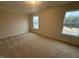 Neutral bedroom with carpeted floors and natural light from two windows overlooking the front yard at 15 Long Needle Ct # 38, Youngsville, NC 27596