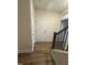 Hallway with wood flooring, a white interior door, and stairs with wood handrail at 15 Long Needle Ct # 38, Youngsville, NC 27596