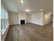 Spacious living room with fireplace, large windows, wood-look flooring, and crown molding at 15 Long Needle Ct # 38, Youngsville, NC 27596