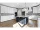 Modern kitchen with white cabinets, a large island, and hardwood floors at 157 Winston Pointe Dr, Clayton, NC 27520