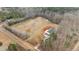 Aerial view of a charming home with a green roof surrounded by vast land at 1696 James Winston Rd, Oxford, NC 27565