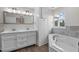 Bathroom with double vanity, corner tub, and tile surround at 1696 James Winston Road Rd, Oxford, NC 27565