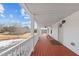 Inviting covered porch with painted floors, railings, ceiling fans, and ample seating space at 1696 James Winston Rd, Oxford, NC 27565