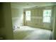 A large bedroom featuring new drywall and a brace of large windows at 301 W College St, Louisburg, NC 27549